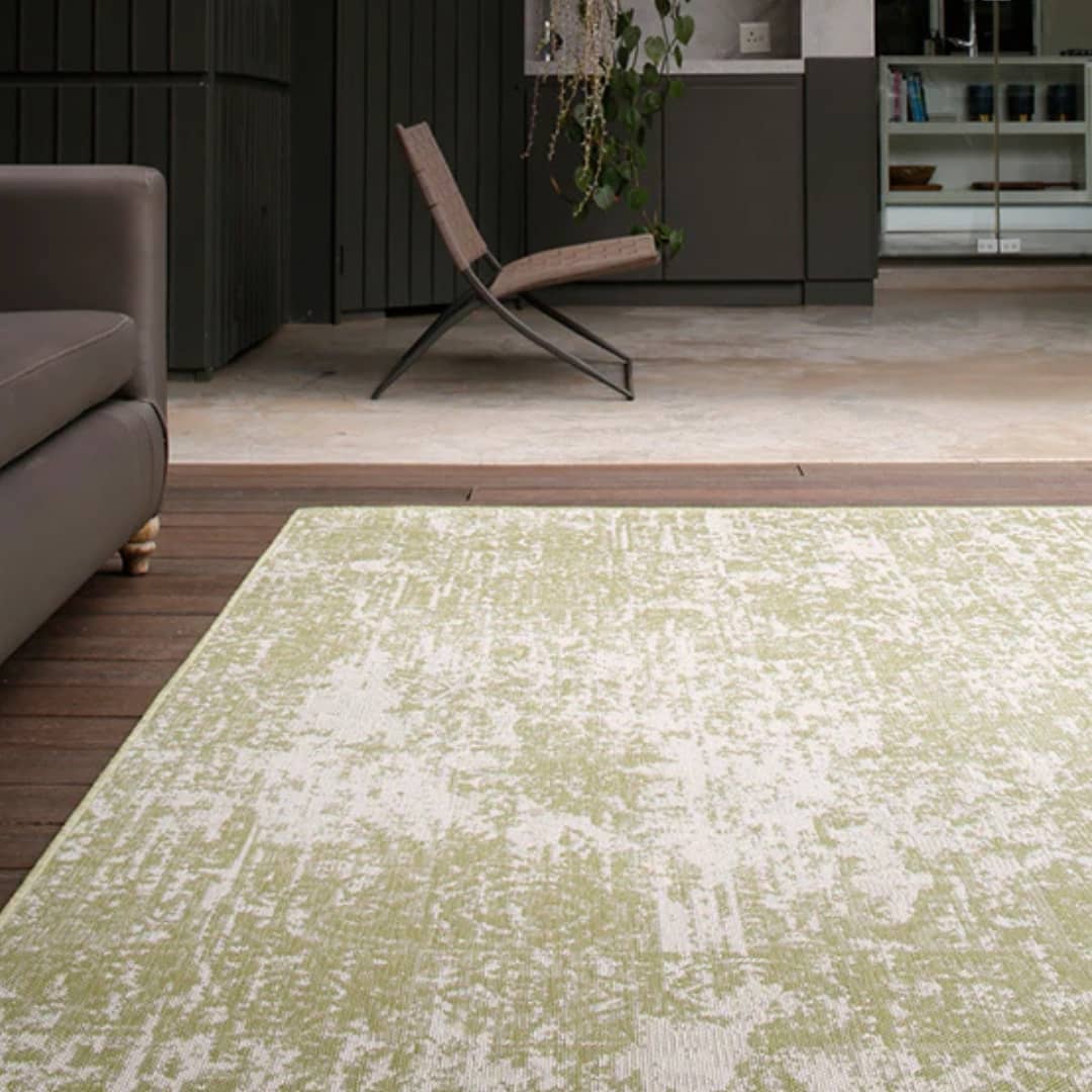 Geometric green and ivory area rug in a living room, enhancing the space with style.