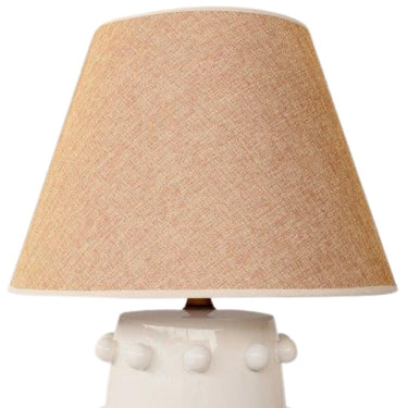 Playful ceramic table lamp with brass details and soft beige glow.