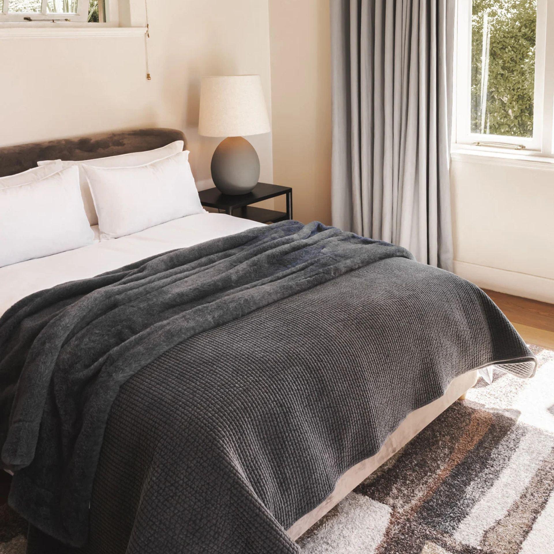 Frostveil Faux Fur displayed over a bed in a bedroom