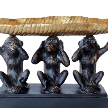close-up of three wise monkeys design with metallic gold bowl