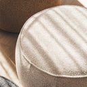 Nigella Ottoman upholstered in Comet Oats fabric with edge piping, swivel base, styled in a modern interior