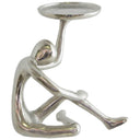 Abstract figure pillar candle holder supporting a round candle plate