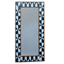 Wall mirror with black and white geometric frame.