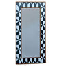 Wall mirror with black and white geometric frame.