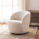 upholstered swivel chair living room on a warm toned rug infron of a dark wood console table