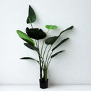 Lifelike artificial tree with broad green leaves of varying shapes