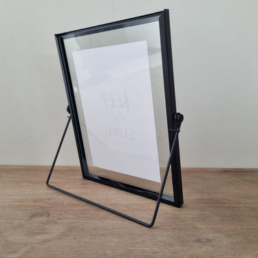 Modern black photo frame with folding hinge and sleek tabletop stand.