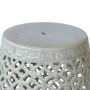 Detail of cut-out ceramic pattern and glossy green glaze on decorative accent stool