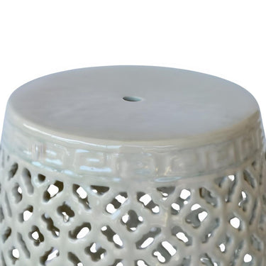 Detail of cut-out ceramic pattern and glossy green glaze on decorative accent stool