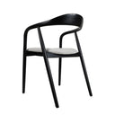 An elegant black coloured dining chair with a curved backrest and cushioned seat.