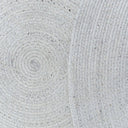 Close-up of a textured gray fabric on the Carousel Round Outdoor Rug in Creme