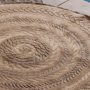 Close-up of a textured round rug with intricate patterns on a tiled floor.
