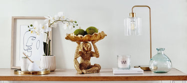 home decor items including a lamp, orchid, and modern decorative accessories from Woodka Interiors