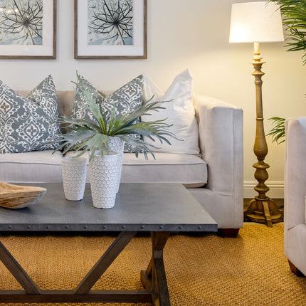 Bright and airy living room styled with spring decor ideas, featuring a light jute rug, botanical wall art, lighting and fresh greenery by Woodka Interiors