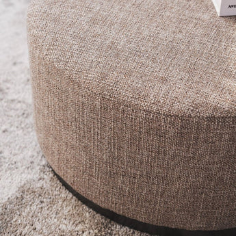 Stylish ottoman with soft fabric, ideal as a footrest or extra seating, adding elegance to any home décor.