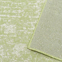 A flat-woven green and white rug with geometric designs, combining contemporary style and nature-inspired aesthetics.