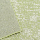 Close-up of a luxurious green rug featuring elegant white and grey accents, perfect for enhancing any sophisticated space.