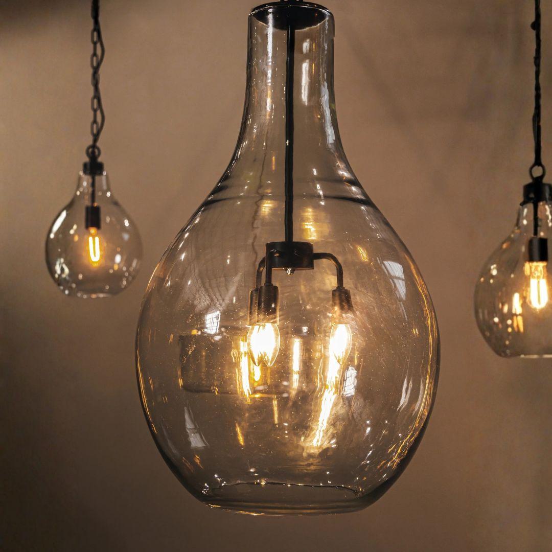 Bell glass pendant lights with visible bulbs against a neutral background