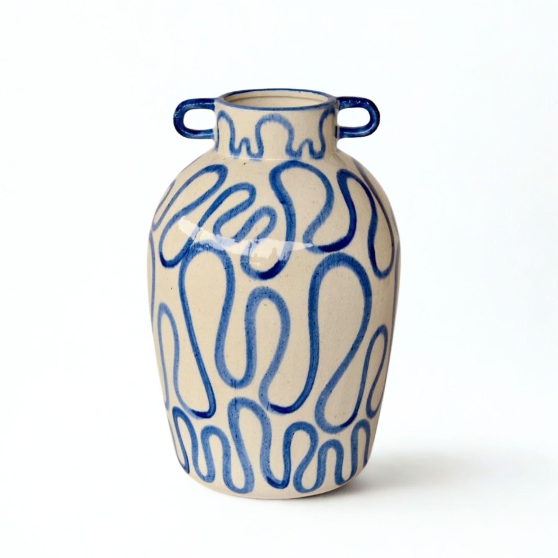 Close-up of decorative ceramic vase with squiggle detailing and glossy ceramic finish