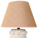 Playful ceramic table lamp with brass details and soft beige glow.
