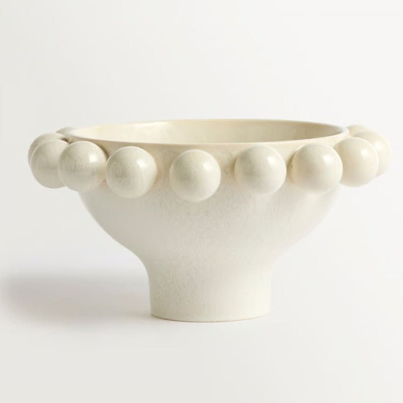 cream ceramic bowl with decorative border of raised spherical beads.