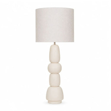 A modern table lamp with a textured off-white fabric drum shade and a sculptural, stacked ceramic base in a matching cream colour.