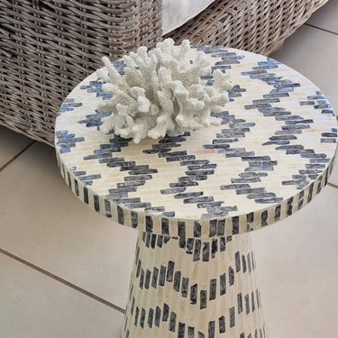 Side Table handcrafted with care and adorned with the finest capiz shell under a out door patio with a stuning coral ornament on top