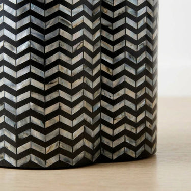 Chevron shell inlay side table  base with black base and iridescent pattern.