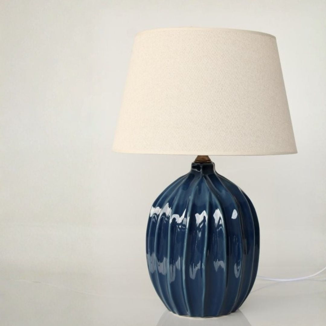Fluted table lamp with a blue ceramic base and beige lampshade 