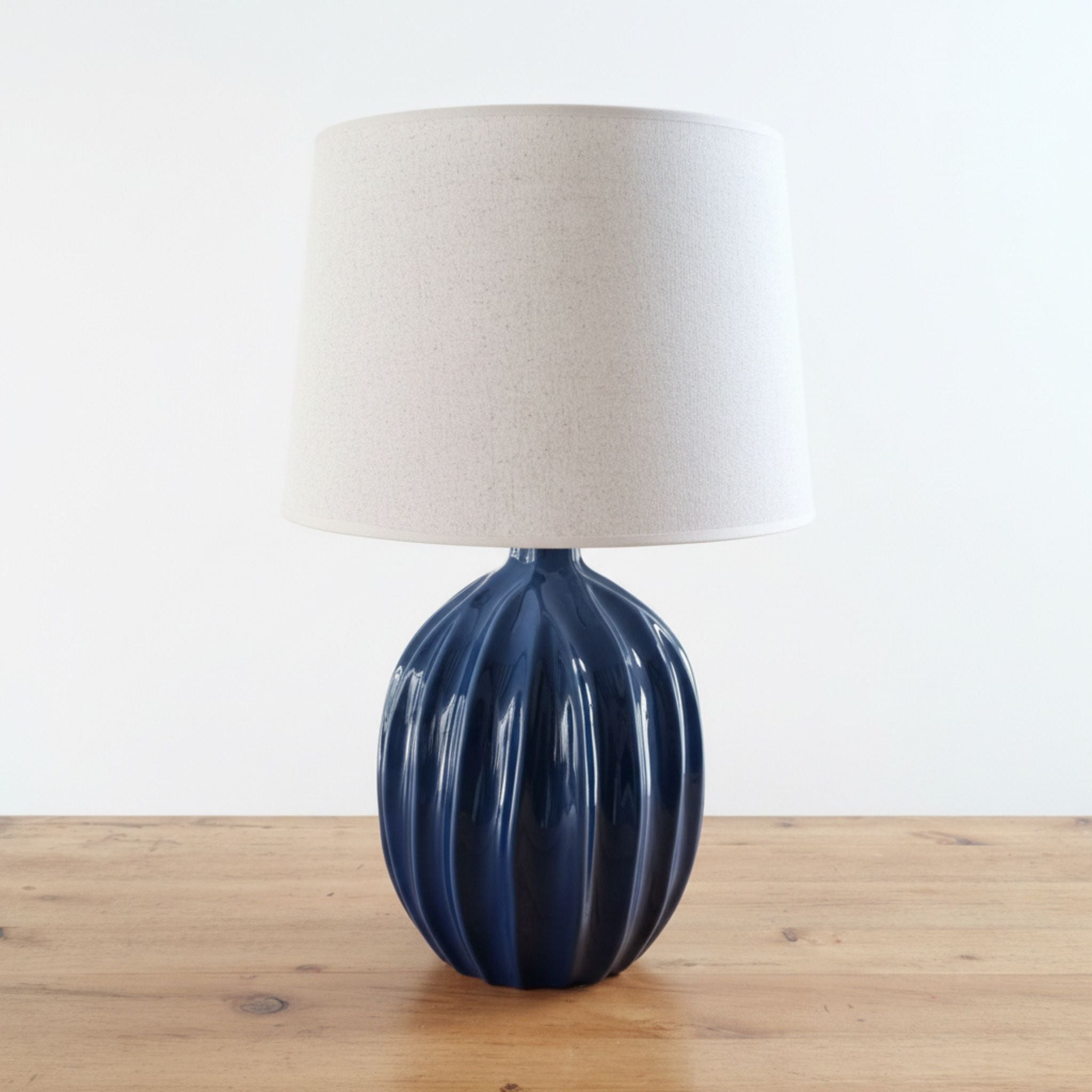 Fluted table lamp with a blue ceramic base and beige lampshade 