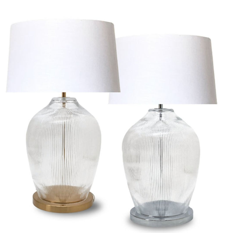 Fluted glass table lamp with a brass or chrome base and white fabric shade.