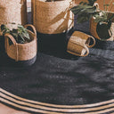 French Riviera Round Rug styled in a modern living room interior with matching decorative baskets