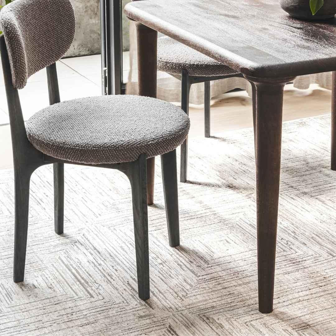  dinning chair on a Laberinto rug designed with an eye-catching concentric pattern 