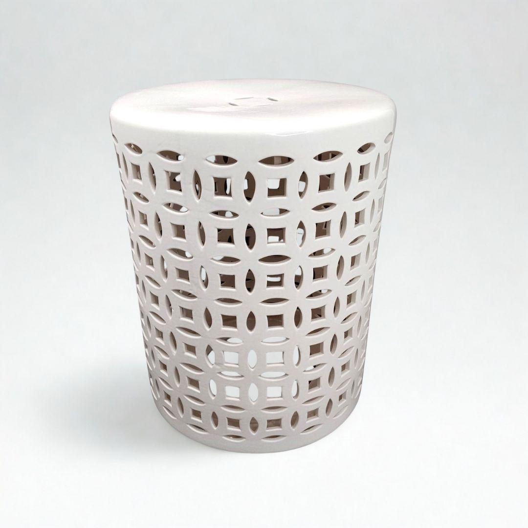 A white ceramic garden stool with pierced geometric lattice cutouts.