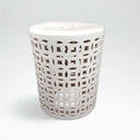 A white ceramic garden stool with pierced geometric lattice cutouts.