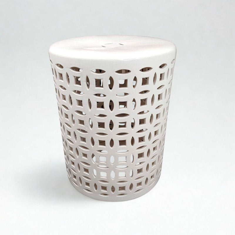 A white ceramic garden stool with pierced geometric lattice cutouts.