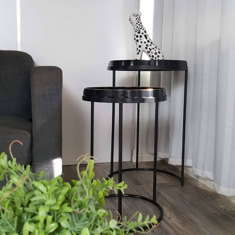 Leah Nesting Side Table Set featuring two round tables with tray tops and matte black powder-coated metal frames, styled next to a modern sofa.