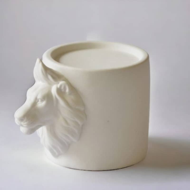 Sculptural lion candle holder in white porcelain with circular top for tealight or small pillar candle.