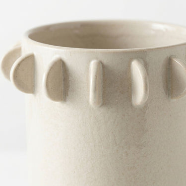 Half-moon scalloped tab edge of a large ceramic vase.