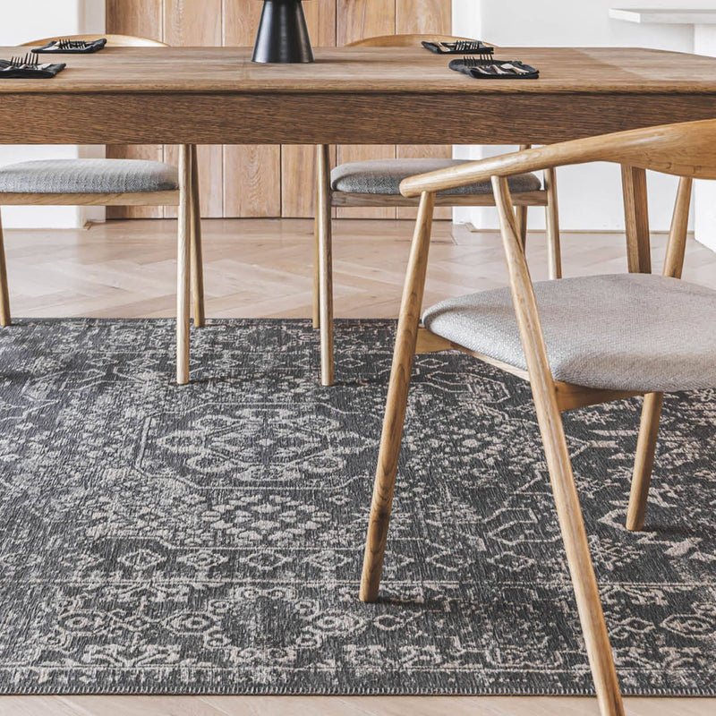 Memoir ink pen charcoal vintage Persian pattern area rug under a wooden dining table.