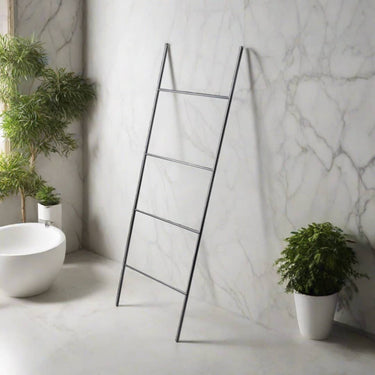 Freestanding matt black towel ladder leaning against a wall, modern industrial metal rail for bathrooms and living rooms.
