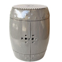 Modern black and white vertical striped ceramic drum stool with double-coin cutouts on a white background.