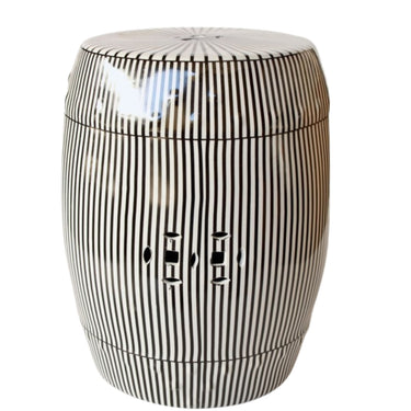 Modern black and white vertical striped ceramic drum stool with double-coin cutouts on a white background.