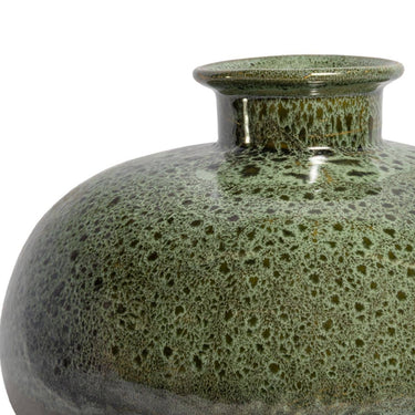 Close-up of the speckled moss green and earthy bronze reactive glaze on a ceramic vessel.