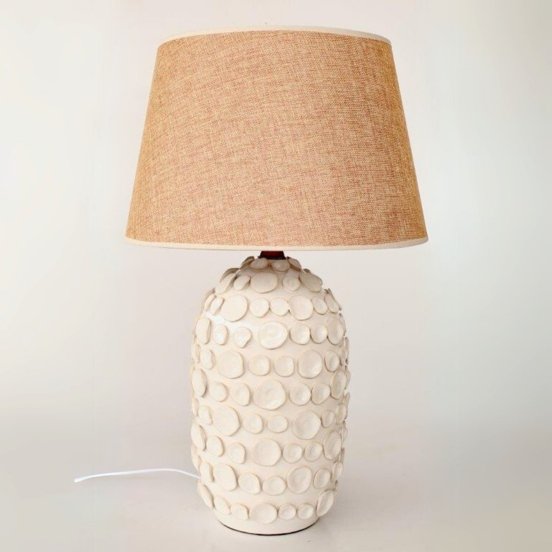 Nature-inspired side lamp with a ceramic petal base and soft glow shade.