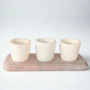 ont view of white marble pinch pots with pink tray on plain white background