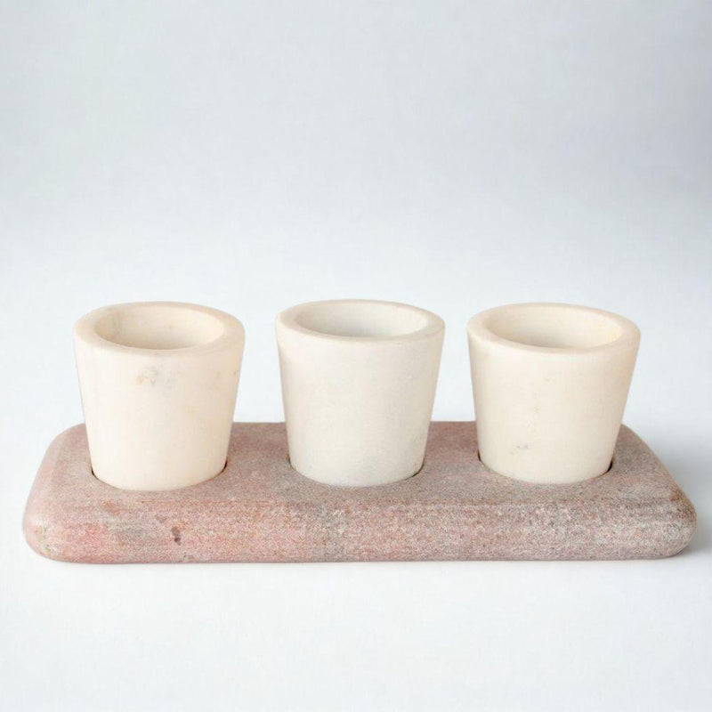 ont view of white marble pinch pots with pink tray on plain white background