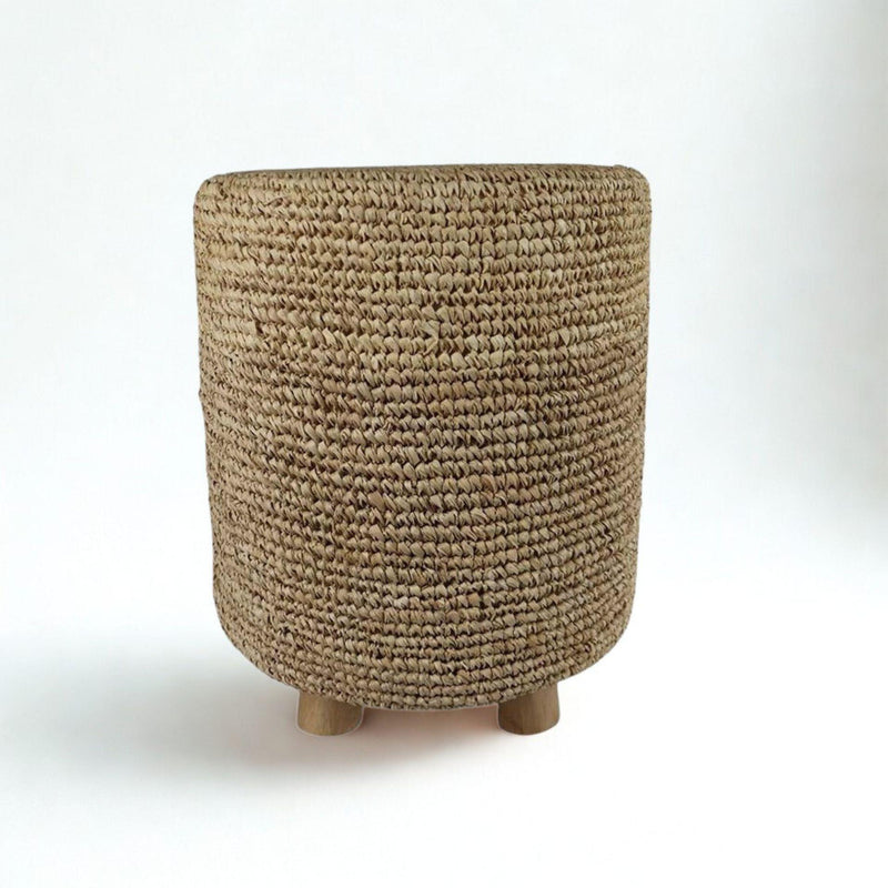 Natural woven stool made from raffia with wooden legs, shown in a natural finish. Elegant decorative stool for boho and relaxed living spaces