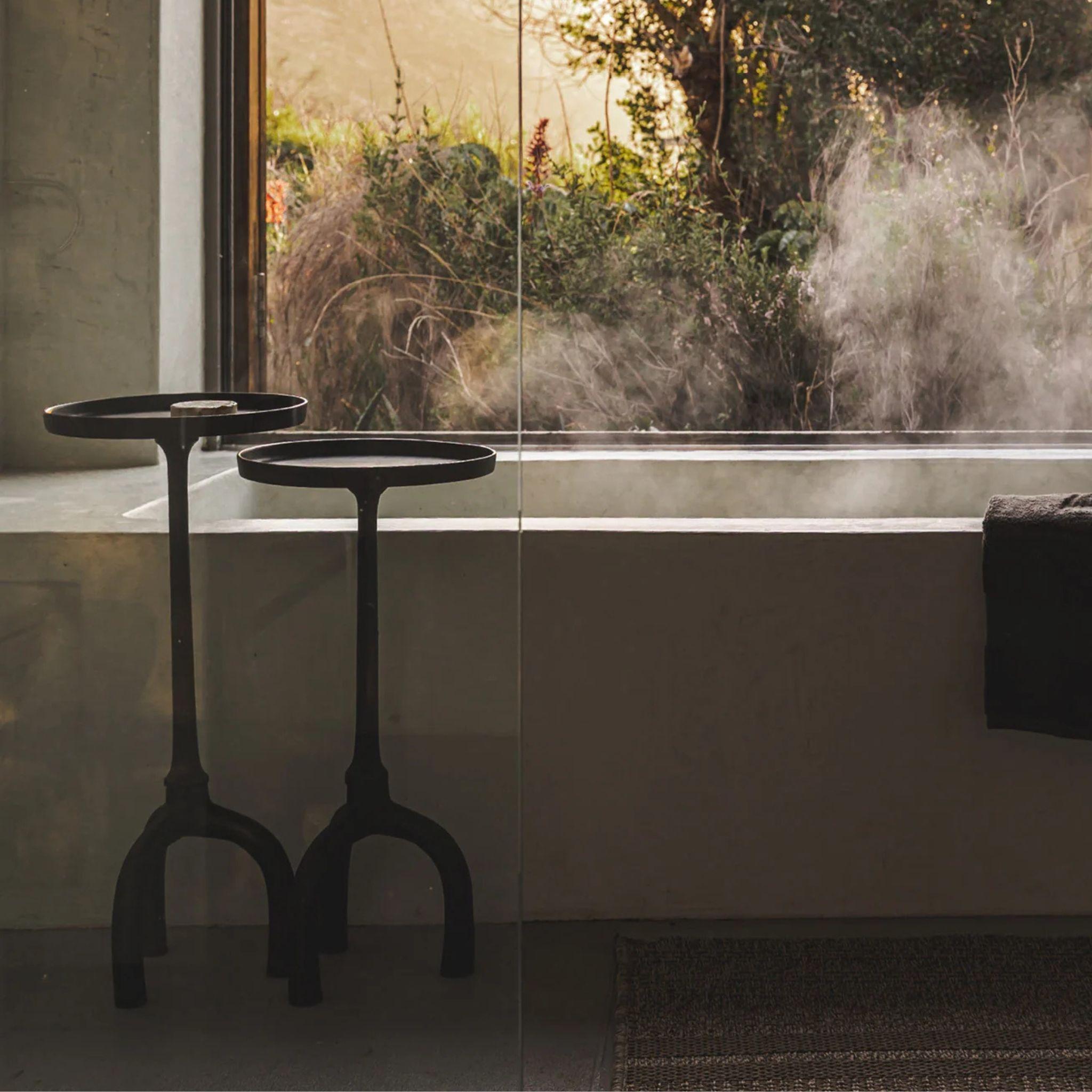 sacred side tables styled in a Modern bathroom with a bathtub