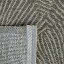 Close-up of a green geometric outdoor rug with a woven geometric shell pattern.
